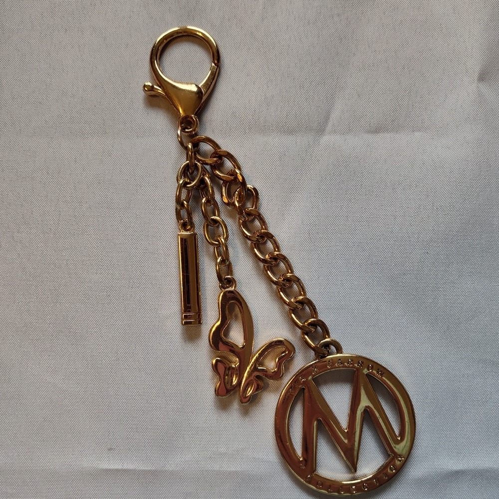 Mia Farrow bag purse keychain gold colored butterfly logo accent fashion